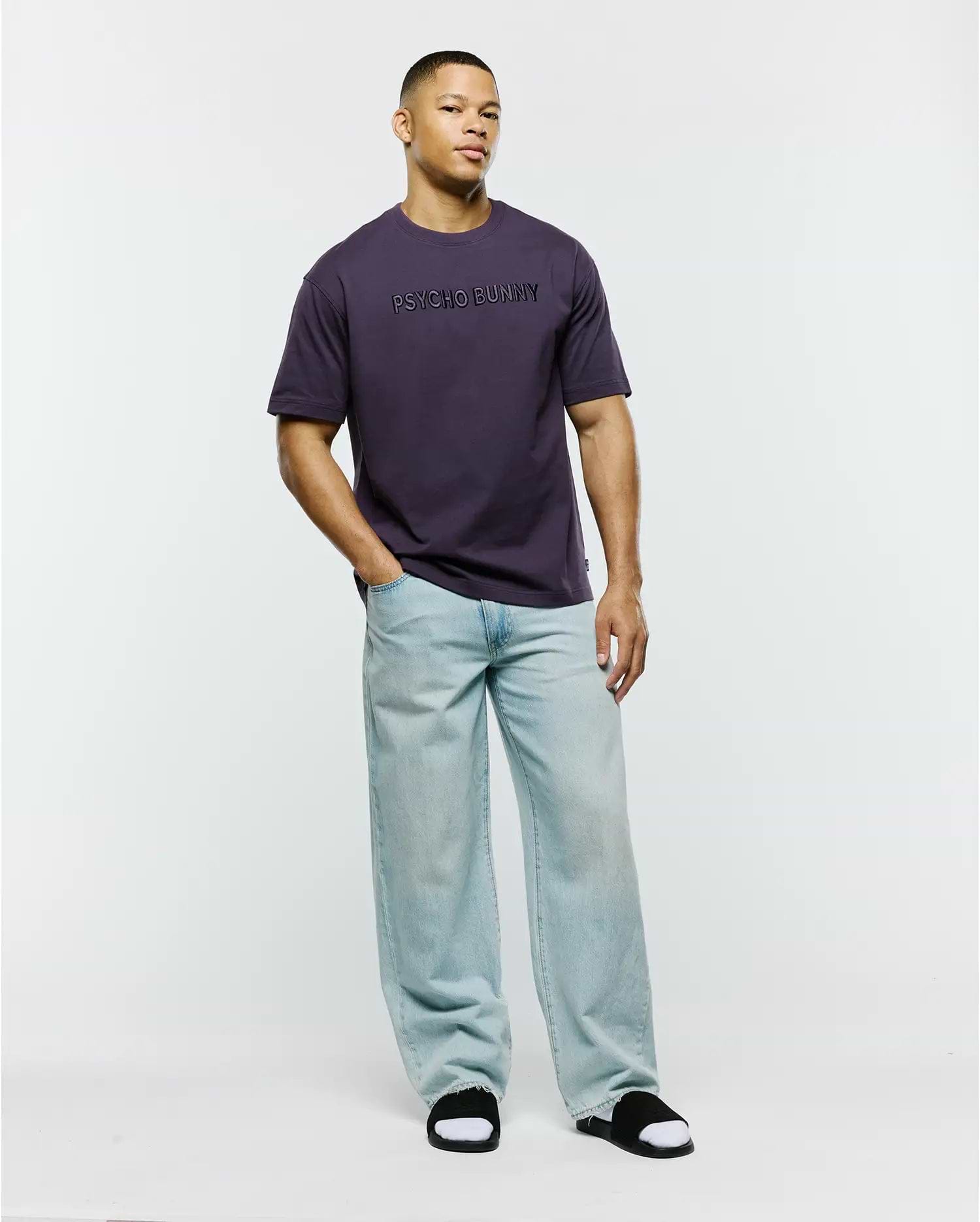 Mens Windcrest Relaxed Fit Tee in deep plum, crafted from smooth jersey knit fabric, featuring a prominent, tonal PSYCHO BUNNY text logo centered on the chest.