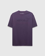 MENS WINDCREST RELAXED FIT TEE in deep plum jersey, featuring a large tonal embossed PSYCHO BUNNY text across the chest and a small embroidered bunny skull logo at the back neck.