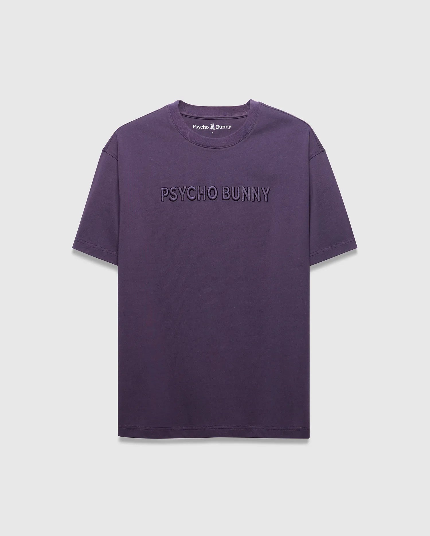 MENS WINDCREST RELAXED FIT TEE in deep plum jersey, featuring a large tonal embossed PSYCHO BUNNY text across the chest and a small embroidered bunny skull logo at the back neck.