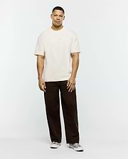 Mens Windcrest Relaxed Fit Tee in cream, crafted from soft jersey, featuring a prominent, tone-on-tone embossed PSYCHO BUNNY text logo centered on the chest. (4)