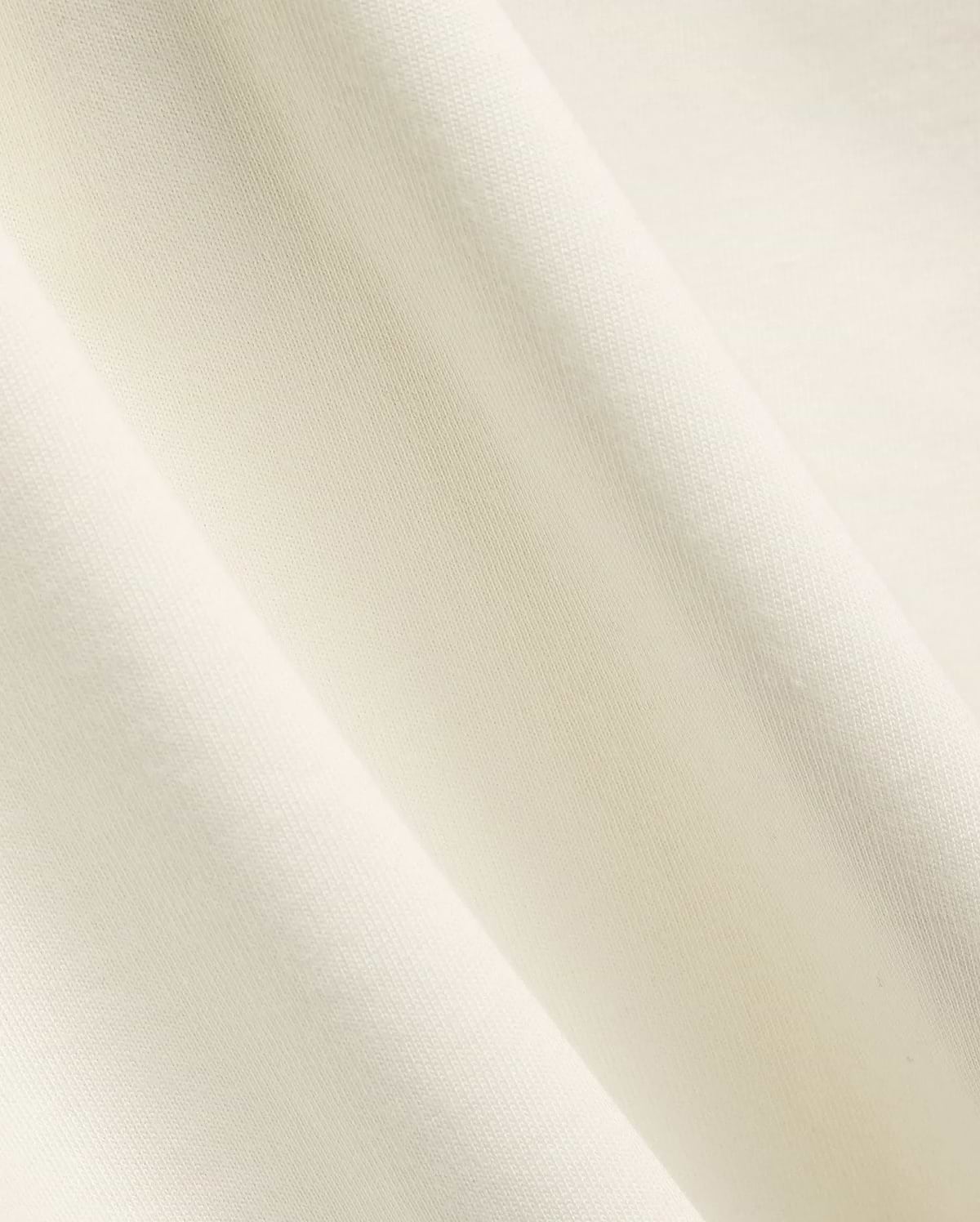 Mens Windcrest Relaxed Fit Tee in a soft, creamy off-white hue, showcasing its premium, smooth fine jersey knit fabric texture with elegant, flowing diagonal folds. (6)