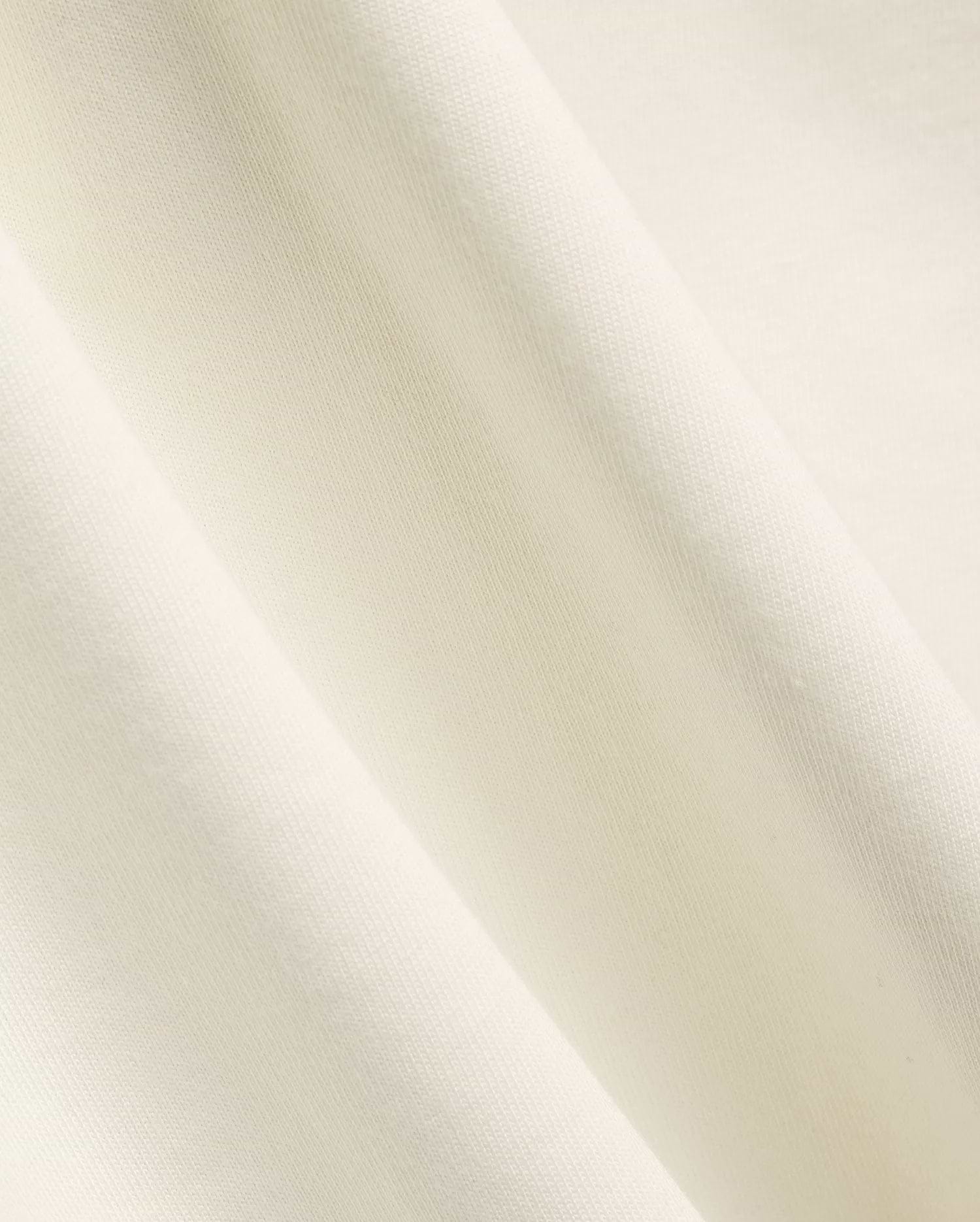 Mens Windcrest Relaxed Fit Tee in a soft, creamy off-white hue, showcasing its premium, smooth fine jersey knit fabric texture with elegant, flowing diagonal folds. (6)