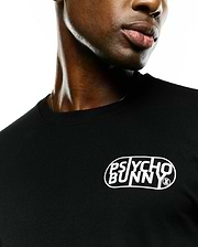 Mens Dariel Long Sleeve Back Graphic Tee in black jersey knit, featuring a white oval graphic print with stylized Psycho Bunny text and a small bunny skull logo on the front chest.
