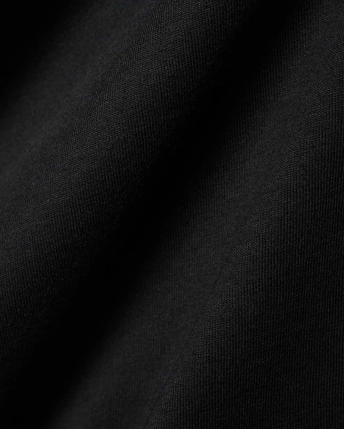Black Mens Dariel Long Sleeve Back Graphic Tee, crafted from premium, soft jersey knit fabric with subtle vertical texture and elegant folds, reflecting refined streetwear quality.