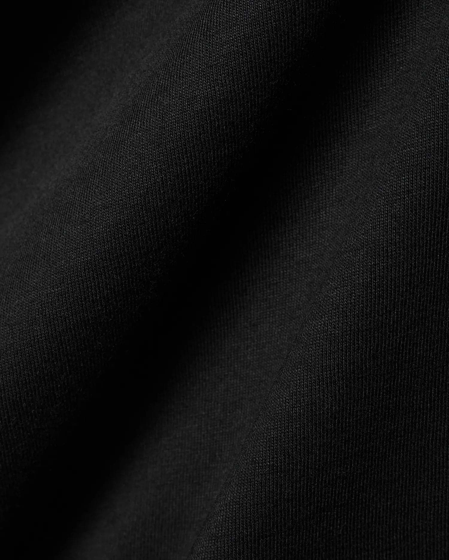 Black Mens Dariel Long Sleeve Back Graphic Tee, crafted from premium, soft jersey knit fabric with subtle vertical texture and elegant folds, reflecting refined streetwear quality.