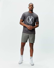 Mens Santa Fe Bunny Graphic Tee, a charcoal grey classic fit jersey t-shirt with a large white circular Psycho Bunny skull graphic on the chest, paired with olive green shorts. (4)