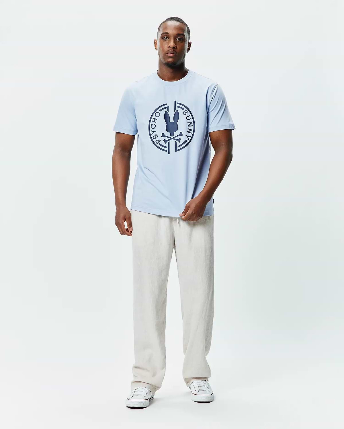 Mens Santa Fe Bunny Graphic Tee, a light blue classic fit jersey t-shirt featuring a large dark blue circular chest graphic with the iconic Psycho Bunny skull and crossbones logo. (4)