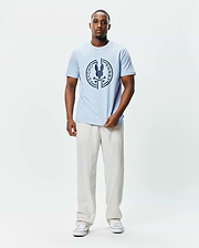 Mens Santa Fe Bunny Graphic Tee, a light blue classic fit jersey t-shirt featuring a large dark blue circular chest graphic with the iconic Psycho Bunny skull and crossbones logo. (4)