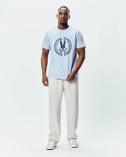 Mens Santa Fe Bunny Graphic Tee, a light blue classic fit jersey t-shirt featuring a large dark blue circular chest graphic with the iconic Psycho Bunny skull and crossbones logo. (4)