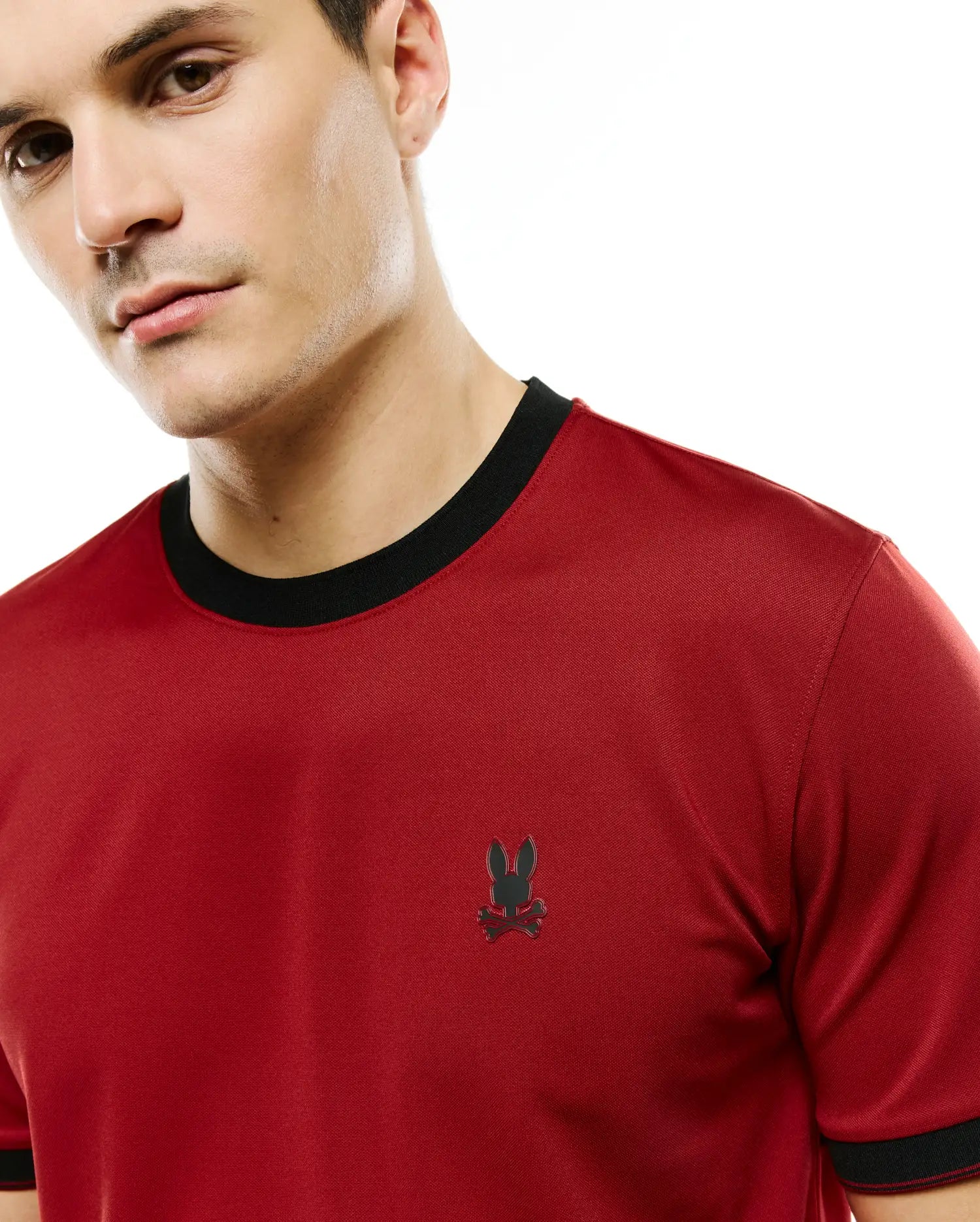Men's Edmonds Chest Bunny Sport Tee, a classic fit red performance jersey t-shirt with black ribbed crew neck and cuffs, featuring a small embroidered black Psycho Bunny skull logo on the left chest. (2)