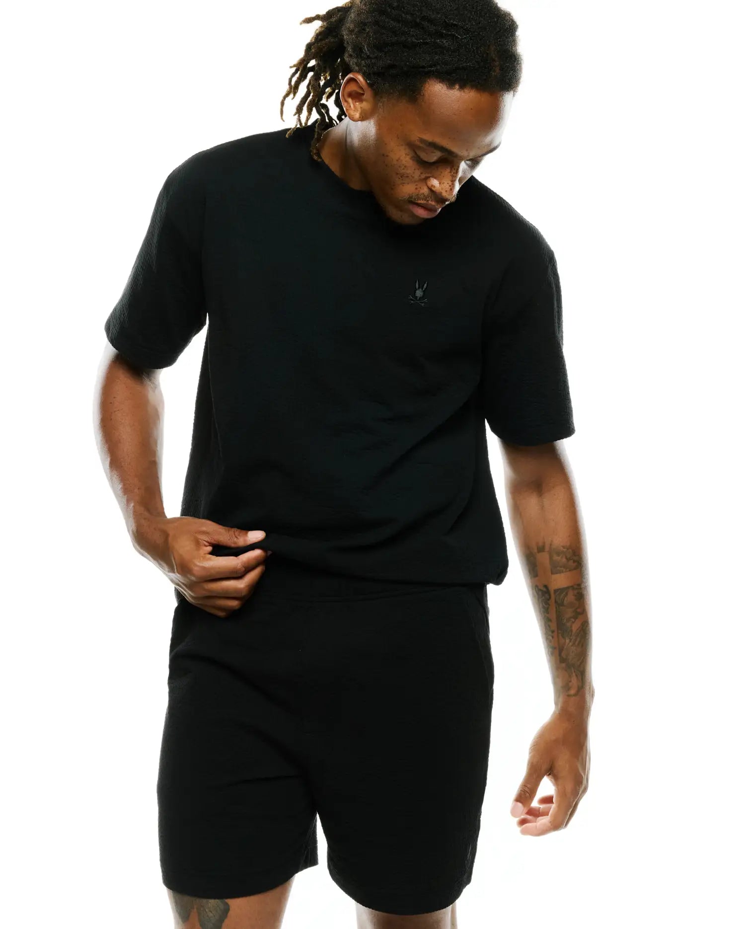 Black Mens Arlen Relaxed Seersucker Tee featuring a distinct textured fabric and a small, tonal embroidered Psycho Bunny skull logo on the left chest.