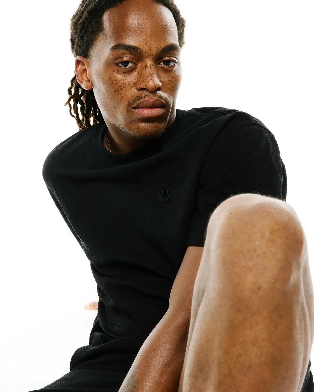Black Mens Arlen Relaxed Seersucker Tee with a subtle seersucker texture and a small embroidered Psycho Bunny skull logo on the left chest.