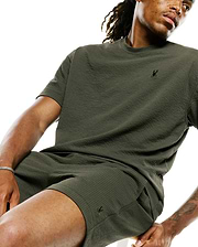Dark olive green MENS ARLEN RELAXED SEERSUCKER TEE featuring a textured seersucker fabric and a small, embroidered black Psycho Bunny skull logo on the left chest.