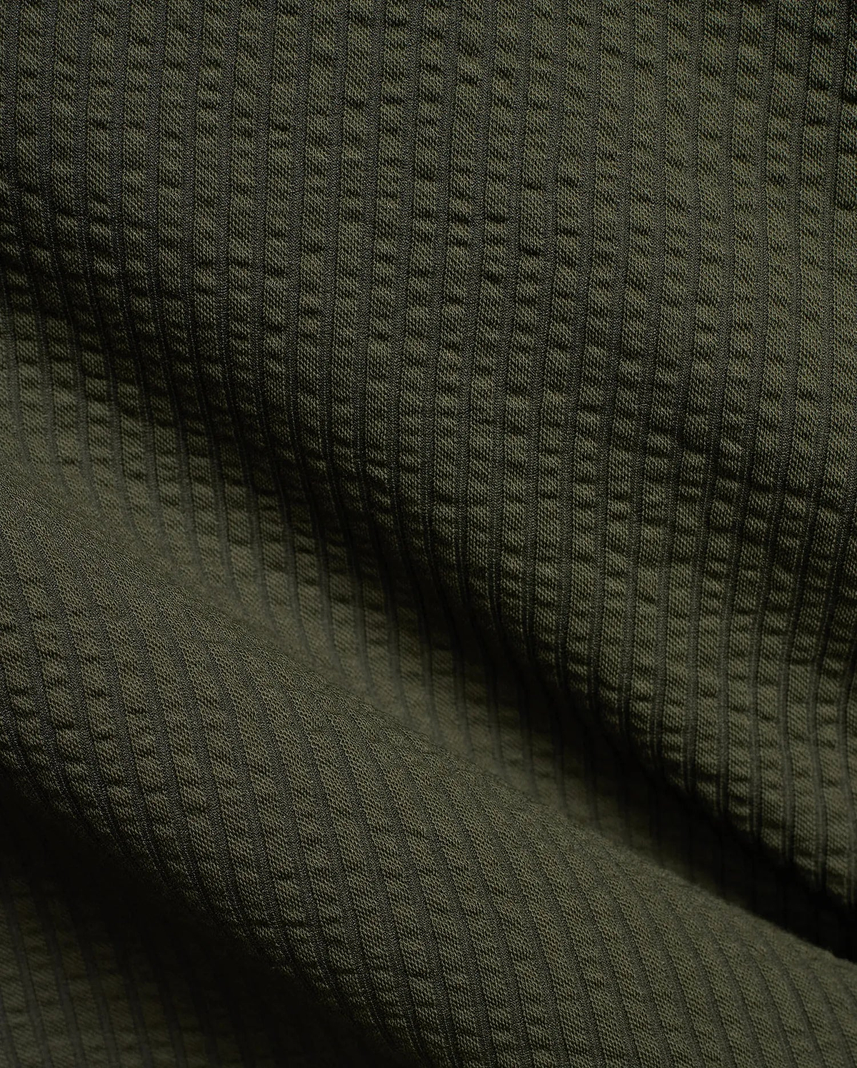 Mens Arlen Relaxed Seersucker Tee in deep olive green, showcasing its distinctive vertical puckered seersucker knit texture with subtle shadows.