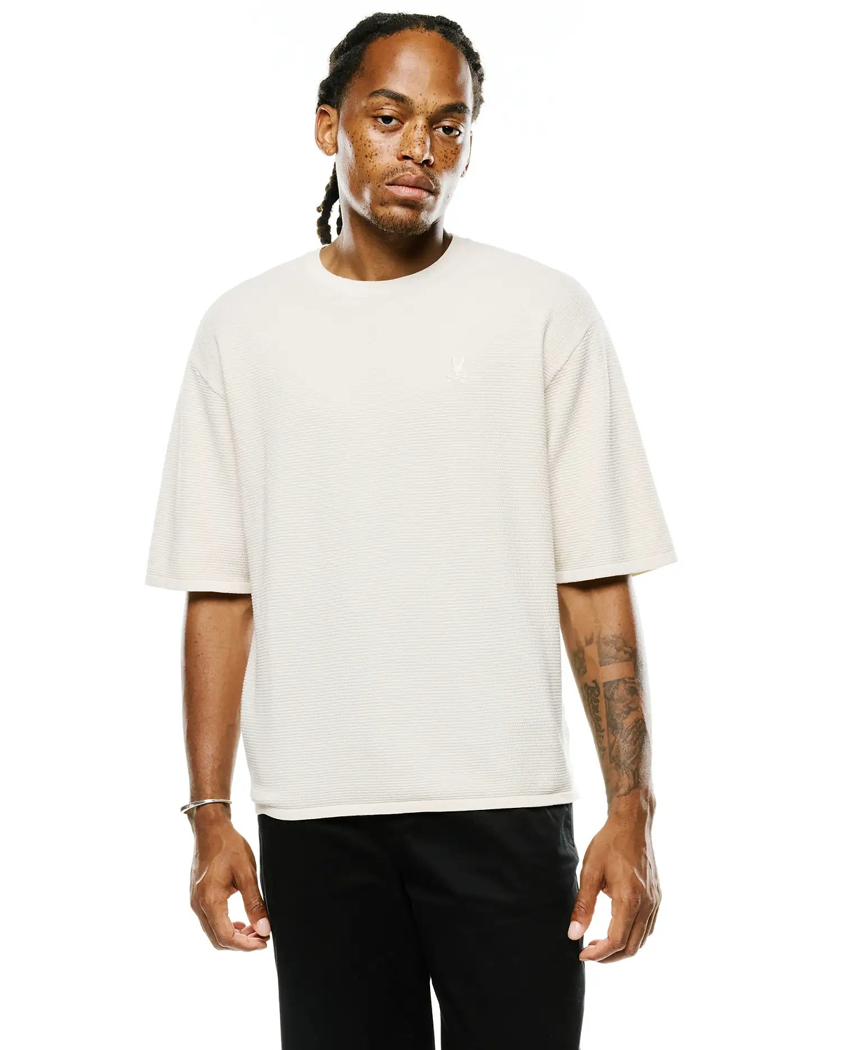 Mens Makai Textured Knit T-Shirt in cream, featuring a relaxed fit, horizontal textured knit fabric, and a small embroidered Psycho Bunny skull logo on the left chest.