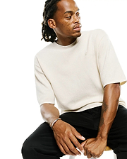 Cream Mens Makai Textured Knit T-shirt, a relaxed fit tee featuring a subtle textured knit fabric and a small, tonal embroidered Psycho Bunny skull logo on the left chest.