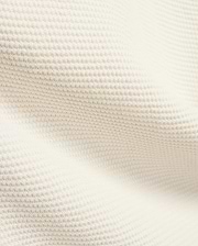 Mens Makai Textured Knit T-Shirt in creamy off-white, showcasing a refined, subtly raised pique-like knit fabric texture, ideal for premium Psycho Bunny streetwear style.