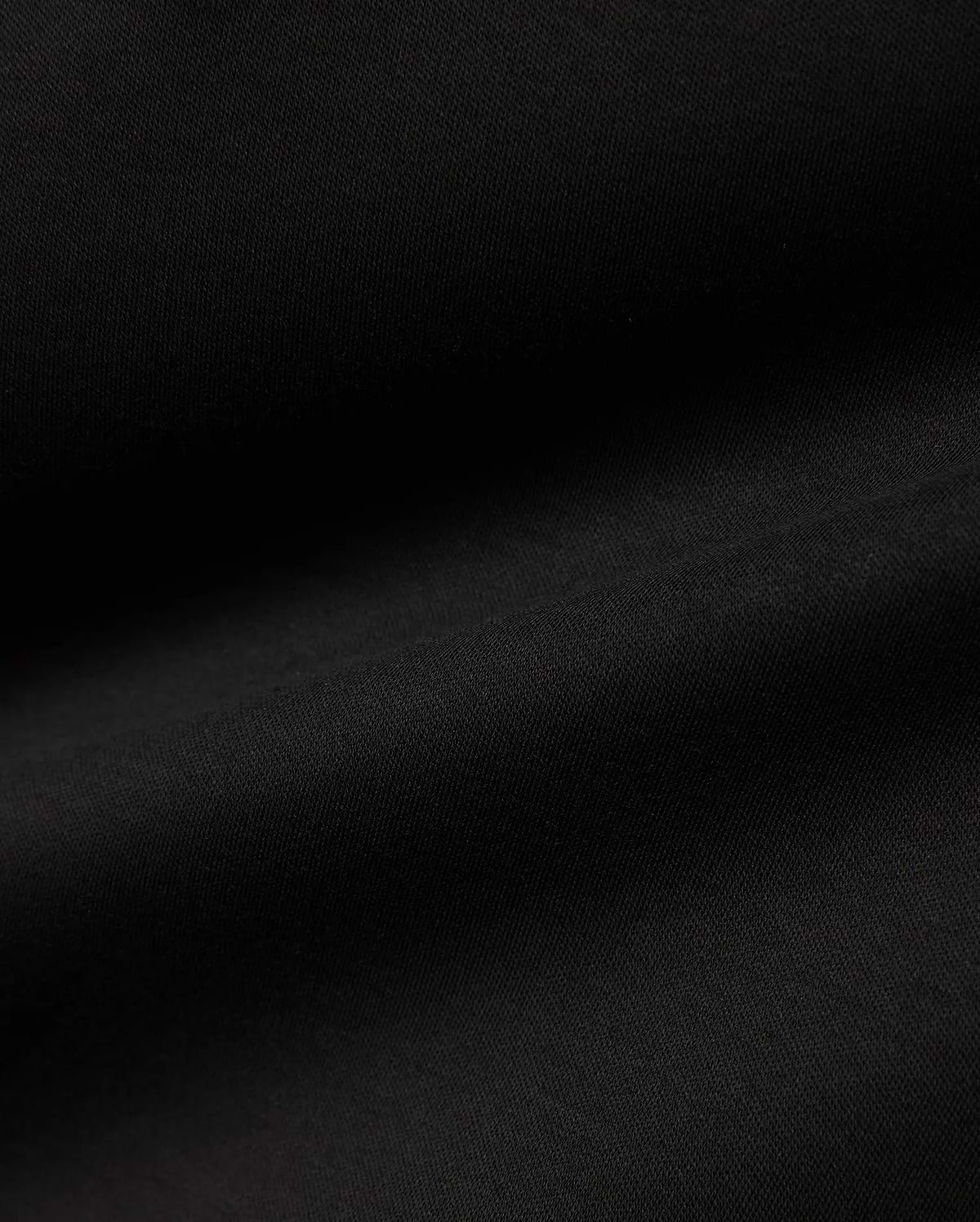 Men's Oscar Longsleeve Tee, a luxurious deep black jersey knit fabric, showcasing a smooth, soft texture with subtle, flowing folds, indicative of premium quality menswear. (6)