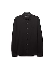 Black Mens Jim Jersey Knit Shirt, a classic fit long-sleeve collared shirt with a smooth jersey knit texture and a small, tonal black embroidered Psycho Bunny skull logo on the left chest.