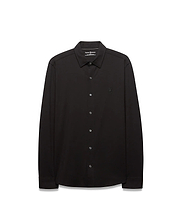 Black Mens Jim Jersey Knit Shirt, a classic fit long-sleeve collared shirt with a smooth jersey knit texture and a small, tonal black embroidered Psycho Bunny skull logo on the left chest.