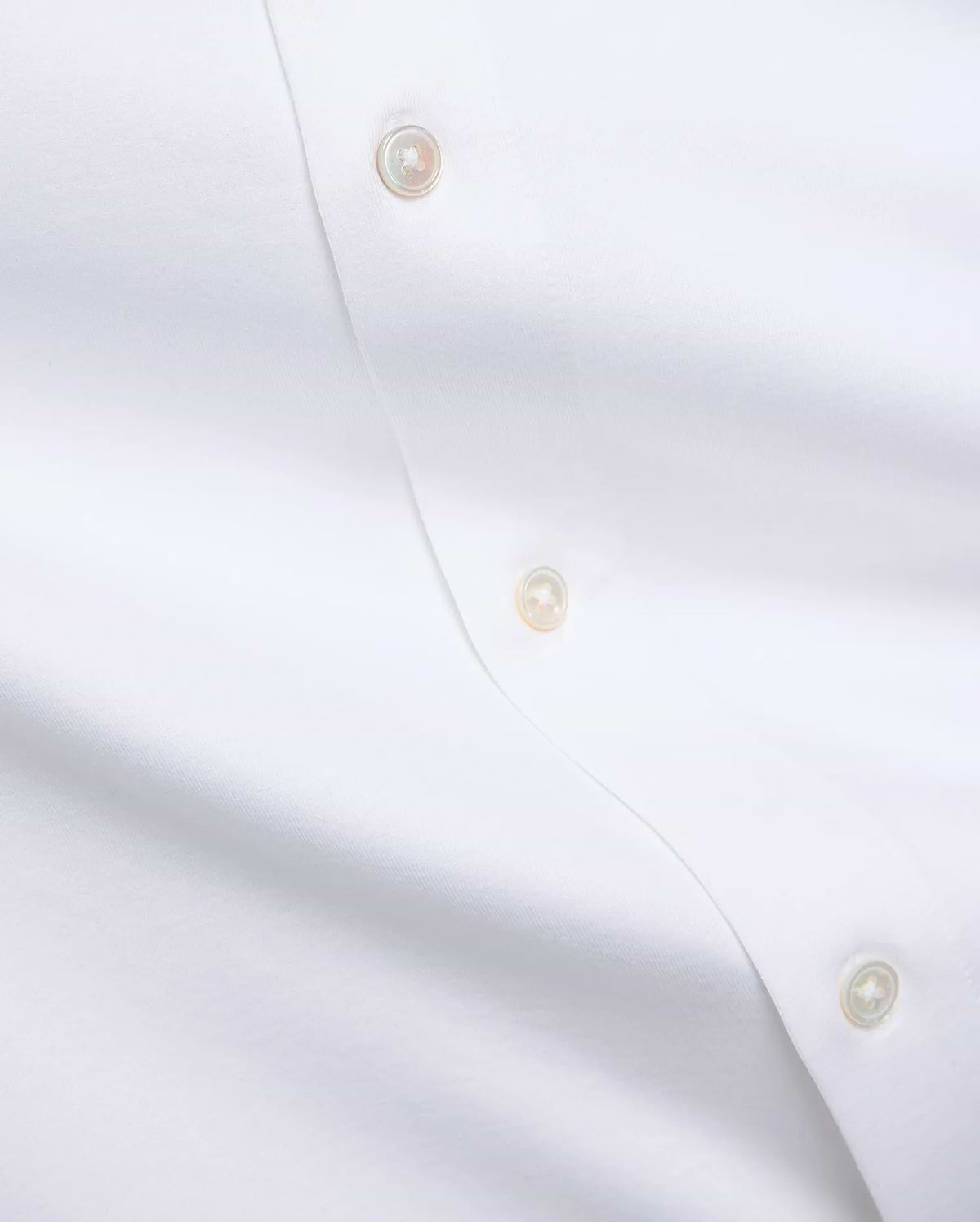 Premium white Jim Jersey Knit Shirt, showcasing a smooth jersey knit fabric and a refined button placket with three iridescent mother-of-pearl buttons. (6)