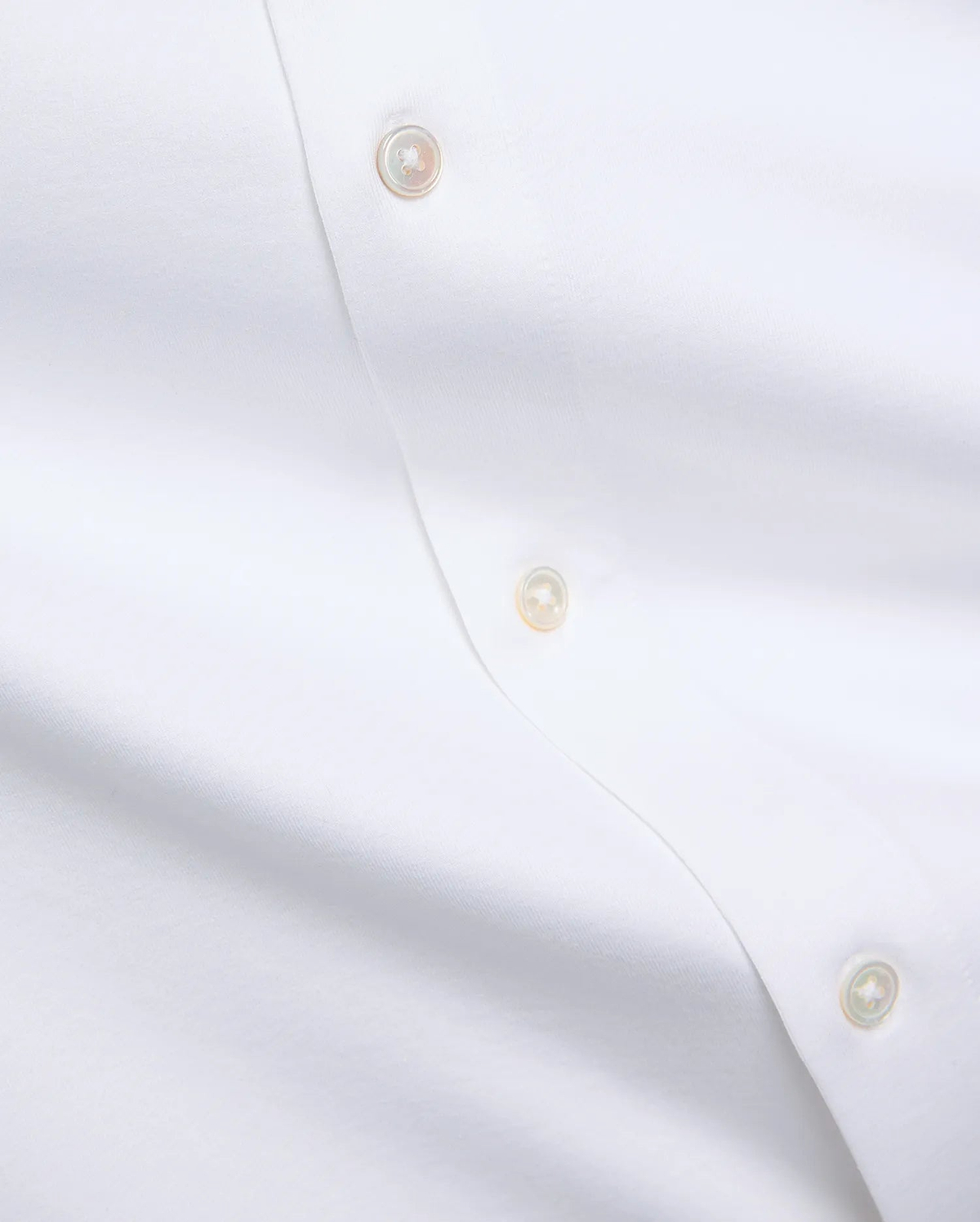 Premium white Jim Jersey Knit Shirt, showcasing a smooth jersey knit fabric and a refined button placket with three iridescent mother-of-pearl buttons. (6)