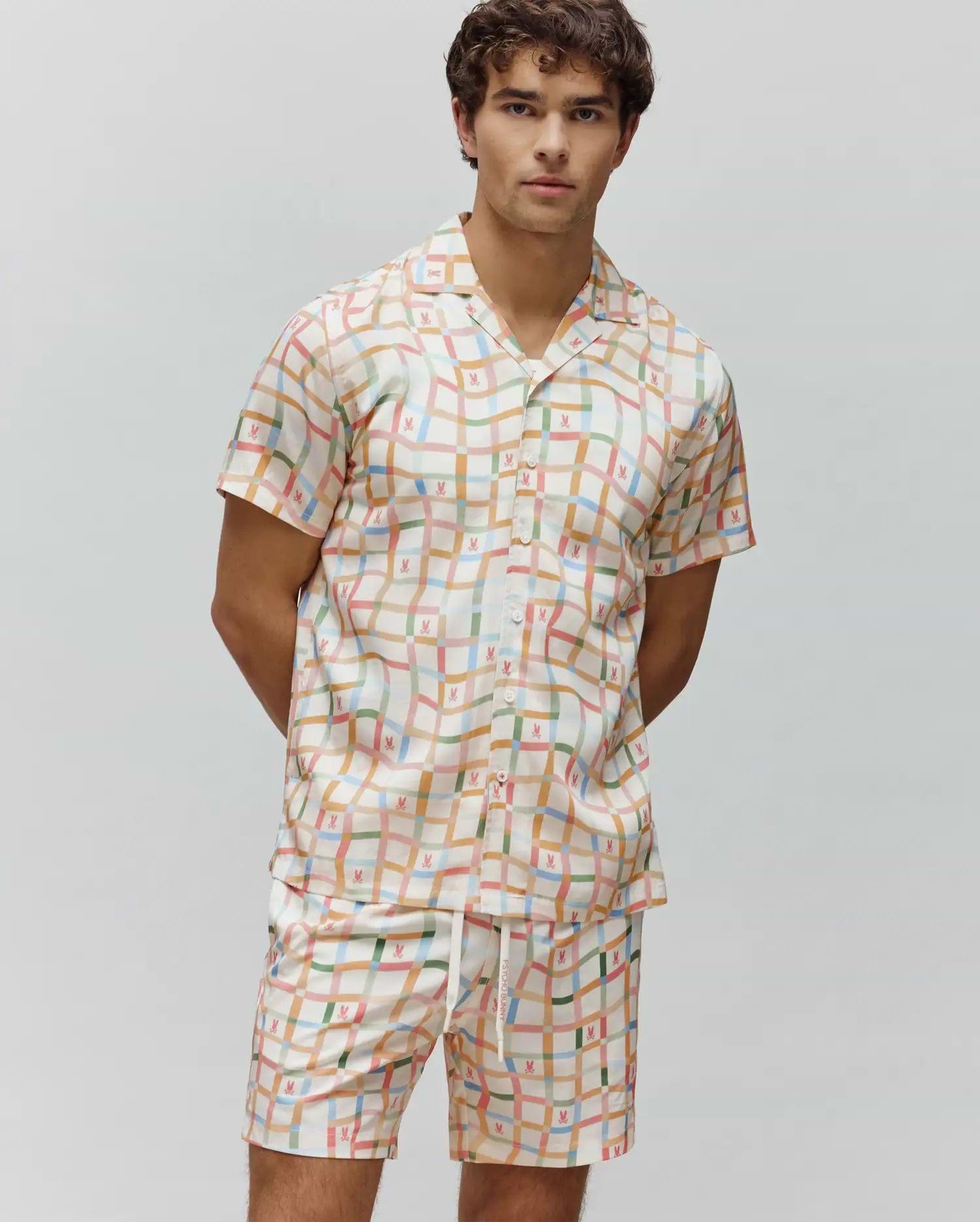 Mens Atlas Tencel Shirt and matching shorts, featuring a relaxed fit, cream base with a wavy multicolor grid pattern, and small repeated Psycho Bunny skull logos throughout.