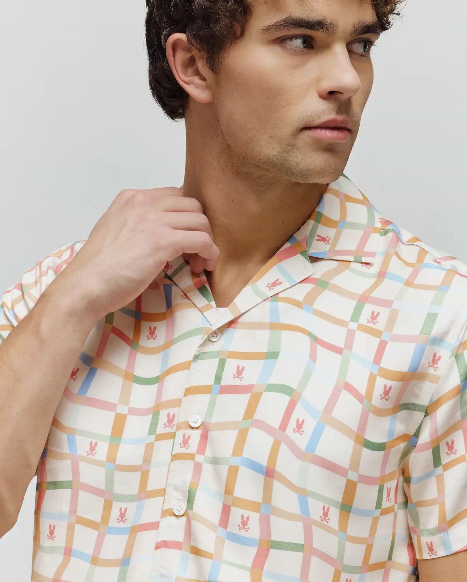 Mens Atlas Tencel Shirt, a relaxed fit, short-sleeved cream shirt with a pastel wavy plaid pattern in pink, blue, green, and orange, featuring small all-over pink Psycho Bunny skull logos.