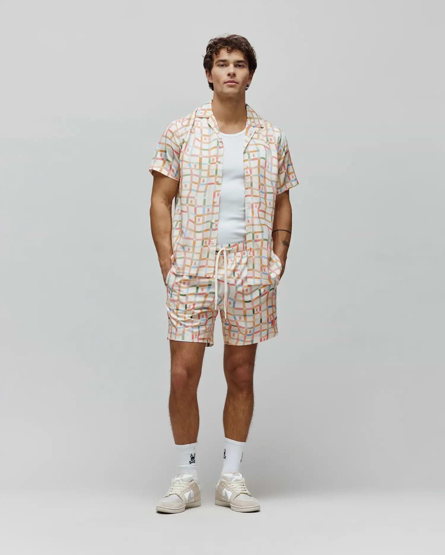 Mens Atlas Tencel Shirt and matching shorts in a relaxed fit, featuring an off-white base with a vibrant multi-colored grid pattern and small repeated Psycho Bunny skull logos.