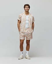Mens Atlas Tencel Shirt and matching shorts in a relaxed fit, featuring an off-white base with a vibrant multi-colored grid pattern and small repeated Psycho Bunny skull logos.
