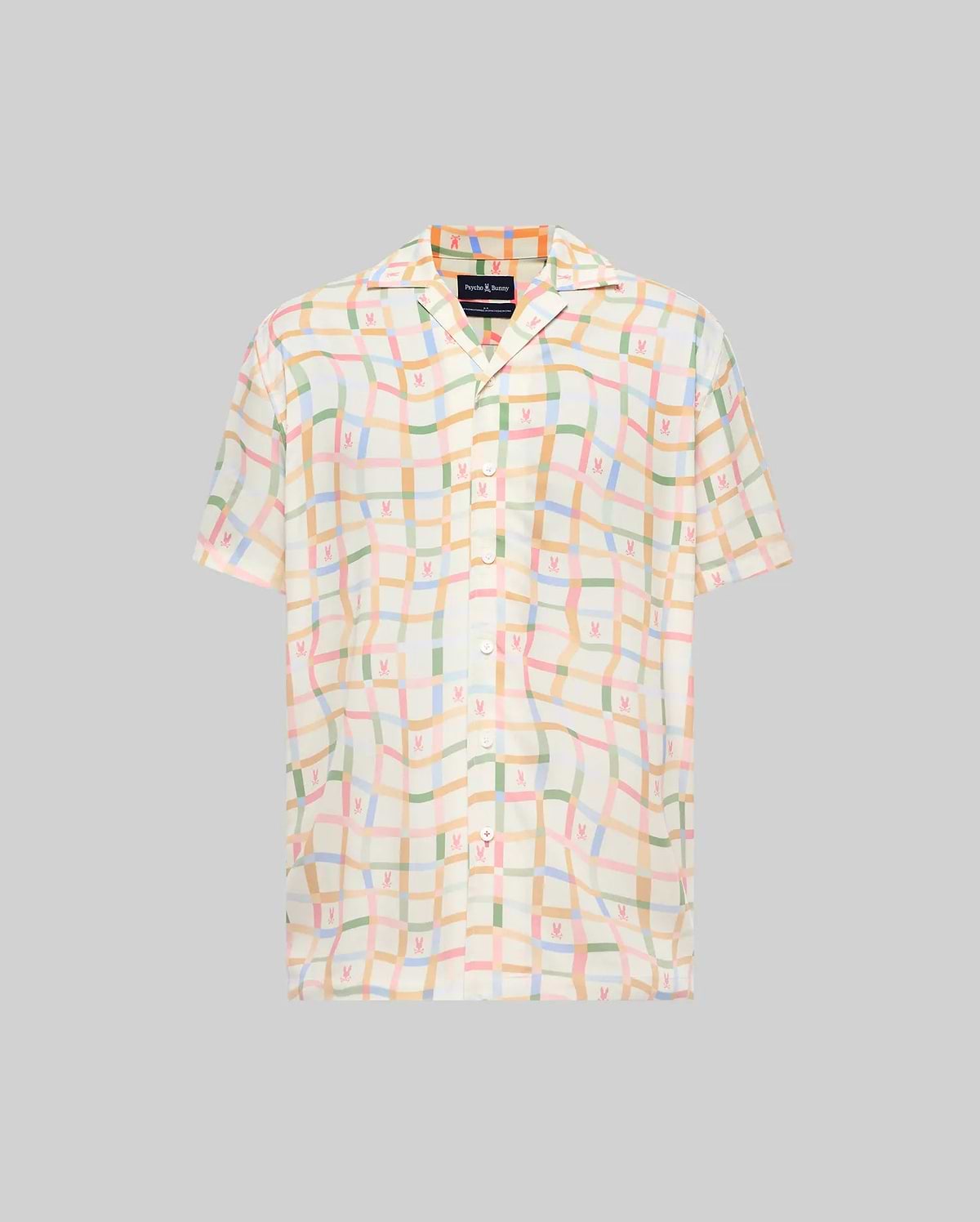 Mens Atlas Tencel Shirt, a relaxed fit short-sleeve shirt in off-white Tencel, featuring an all-over pastel grid pattern with subtle repeated Psycho Bunny skull logos and a camp collar.
