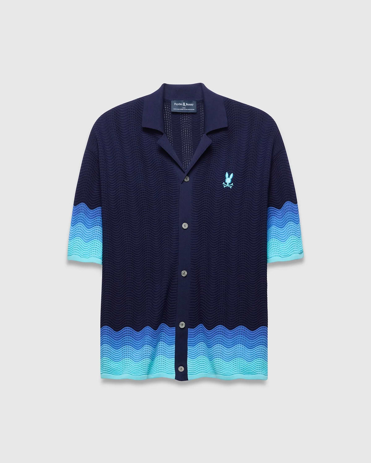 Mens Holden Oversized Knit Shirt: Navy blue wavy knit with camp collar, button-front, and light blue to turquoise wavy color block hem and sleeve cuffs. Embroidered light blue Psycho Bunny skull logo on left chest. (5)