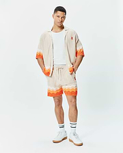 Mens Holden Relaxed Fit Knit Shirt and matching shorts in beige knit with orange and white wavy stripes, featuring a small embroidered orange Psycho Bunny skull logo on the left chest and left thigh. (4)