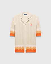 Cream Mens Holden Relaxed Fit Knit Shirt with a wavy texture, featuring an orange and peach ombre stripe on the sleeves and hem, and an embroidered orange Psycho Bunny skull logo on the left chest. (5)