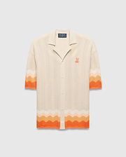 Cream Mens Holden Relaxed Fit Knit Shirt with a wavy texture, featuring an orange and peach ombre stripe on the sleeves and hem, and an embroidered orange Psycho Bunny skull logo on the left chest. (5)