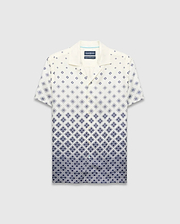 Mens Tobias Tencel Shirt, a relaxed fit cream short-sleeve camp collar shirt with a navy blue diamond pattern that intensifies downwards, featuring the iconic Psycho Bunny skull logo.