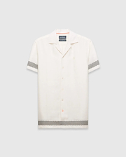 Mens Sunny Linen Shirt, an off-white relaxed linen camp collar shirt, features black zigzag patterns on sleeves and hem, an embroidered Psycho Bunny logo left chest, and orange collar trim. (5)