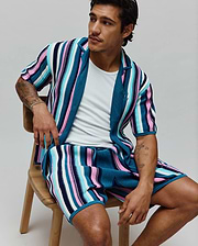 MENS CLIFF SHIRT, a relaxed fit, short-sleeve knit shirt in vibrant teal, pink, white, and navy vertical stripes, featuring a small embroidered Psycho Bunny skull logo on the chest. (3)