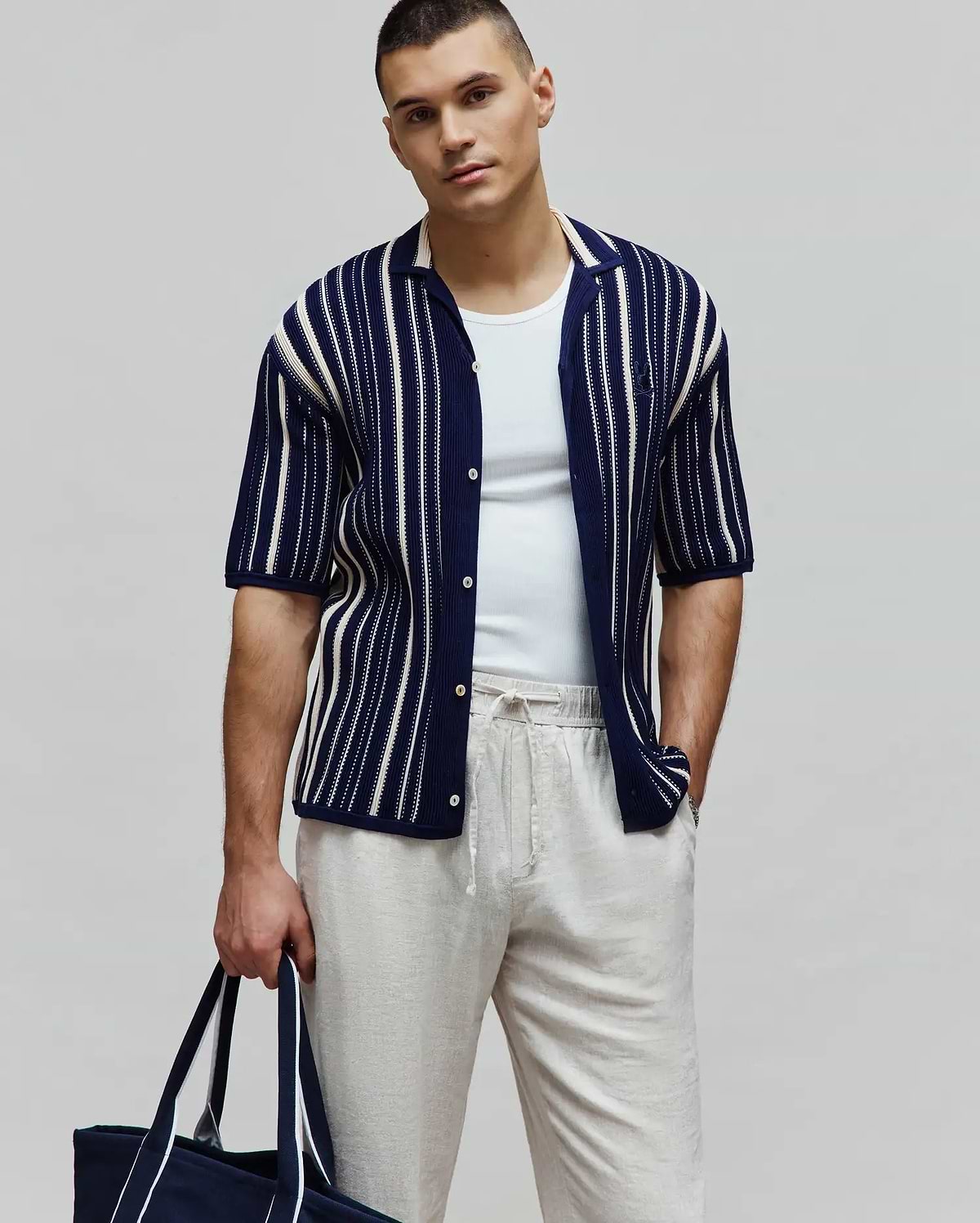 Mens Cliff Shirt, navy blue knit short-sleeve button-up with white vertical stripes, relaxed fit, textured fabric, and a small embroidered Psycho Bunny skull logo on the left chest.