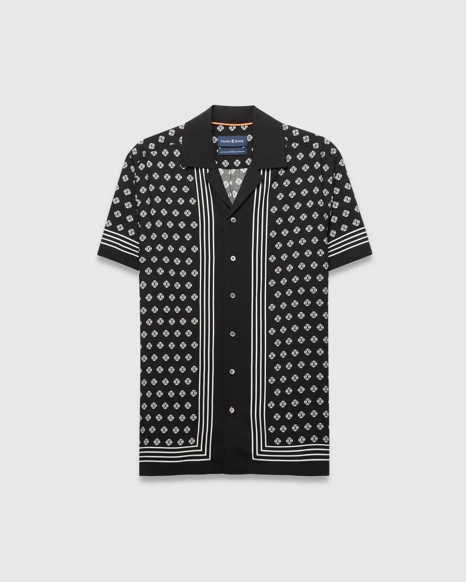MENS NICK TENCEL SHIRT, a black camp collar shirt with a white repeating Psycho Bunny monogram pattern, vertical placket stripes, and horizontal sleeve and hem stripes, offering a relaxed fit.