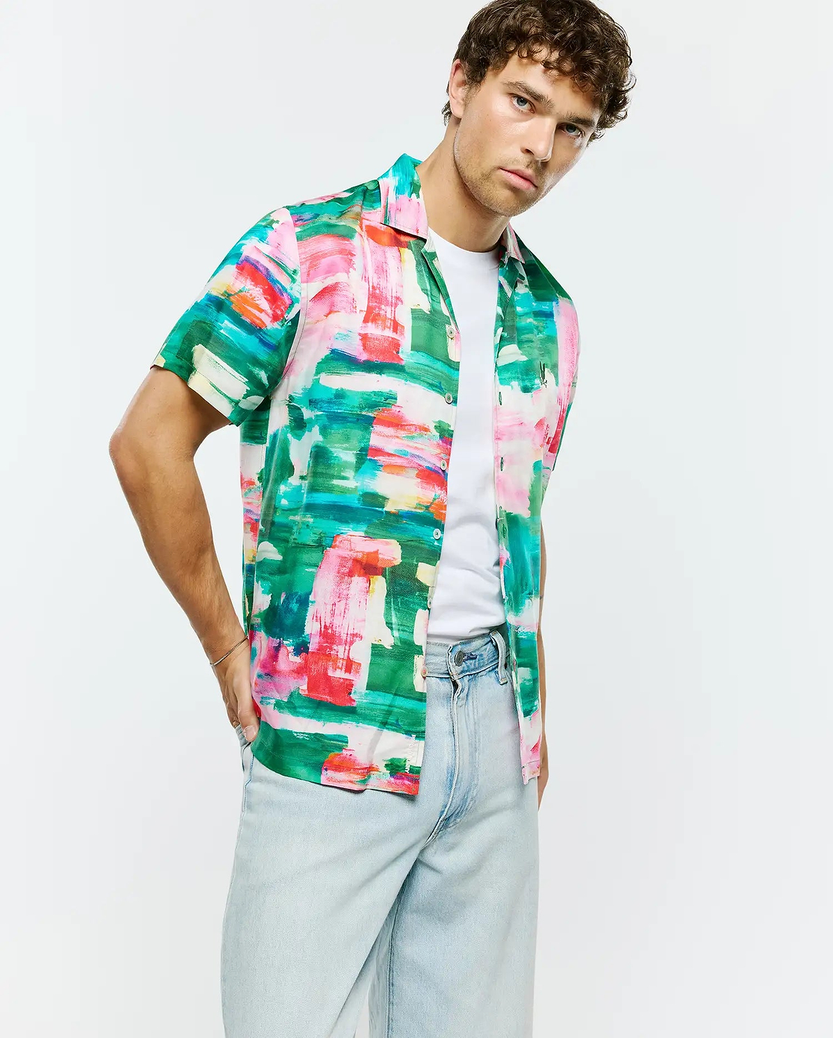 Vibrant green, pink, red, blue, white abstract brushstroke print Mens Nate Tencel Shirt. Relaxed short-sleeve, smooth Tencel fabric, with a small embroidered Psycho Bunny skull logo on the left chest.