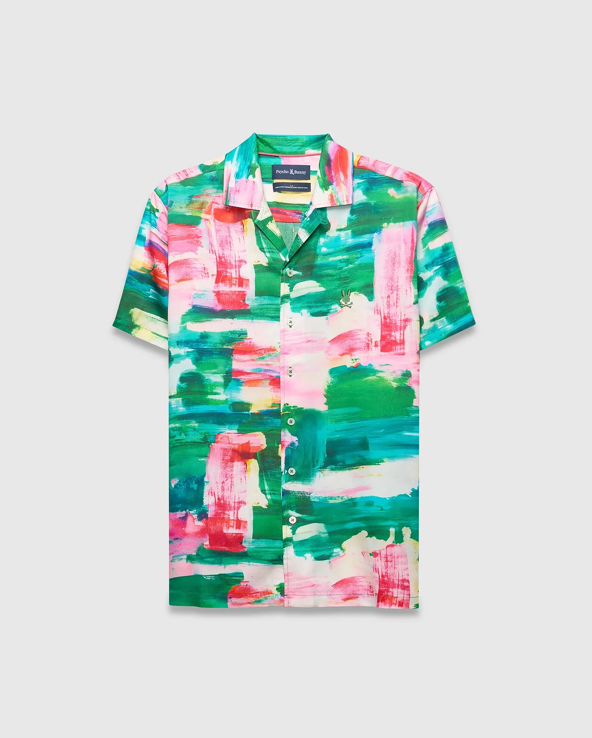 Mens Nate Tencel Shirt, a relaxed fit short-sleeve camp collar shirt in smooth Tencel, featuring a vibrant abstract brushstroke print in green, pink, red, and white, with a small embroidered Psycho Bunny skull logo on the left chest.