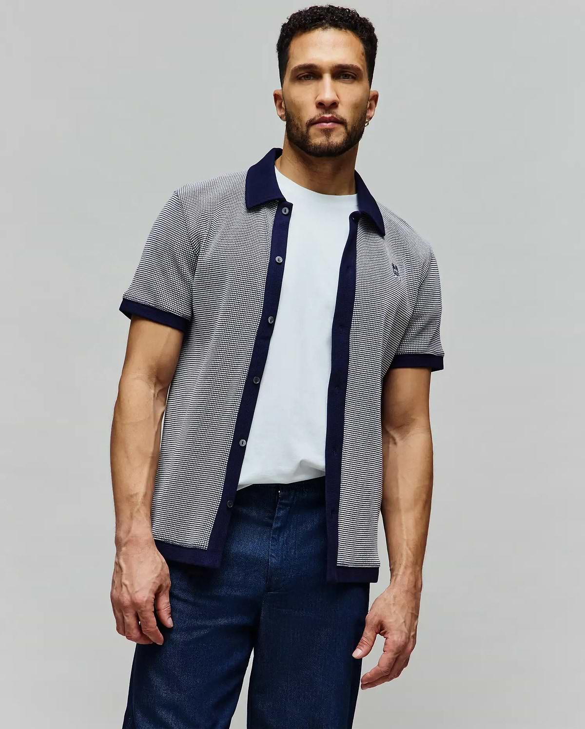 Mens Maxton Waffle Shirt, a classic fit short-sleeve knit shirt in navy and white micro-patterned waffle fabric with solid navy collar, placket, and cuffs, featuring a small embroidered Psycho Bunny skull logo on the left chest.