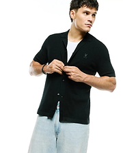 Black Mens Yann Knit Shirt, a classic fit, short-sleeve, full button-front with a ribbed knit texture, spread collar, and a small embroidered Psycho Bunny skull logo on the left chest.