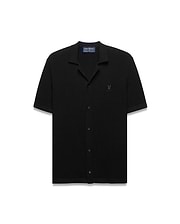 Black Mens Yann Knit Shirt with a classic fit, featuring a ribbed knit texture, full button-front, spread collar, short sleeves, and a small embroidered Psycho Bunny skull logo on the left chest.