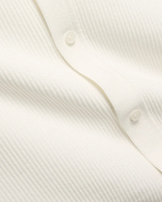 Mens Yann Knit Shirt by Psycho Bunny, a crisp white knit top with a subtle diagonal chevron pattern, featuring a clean button placket with translucent buttons.