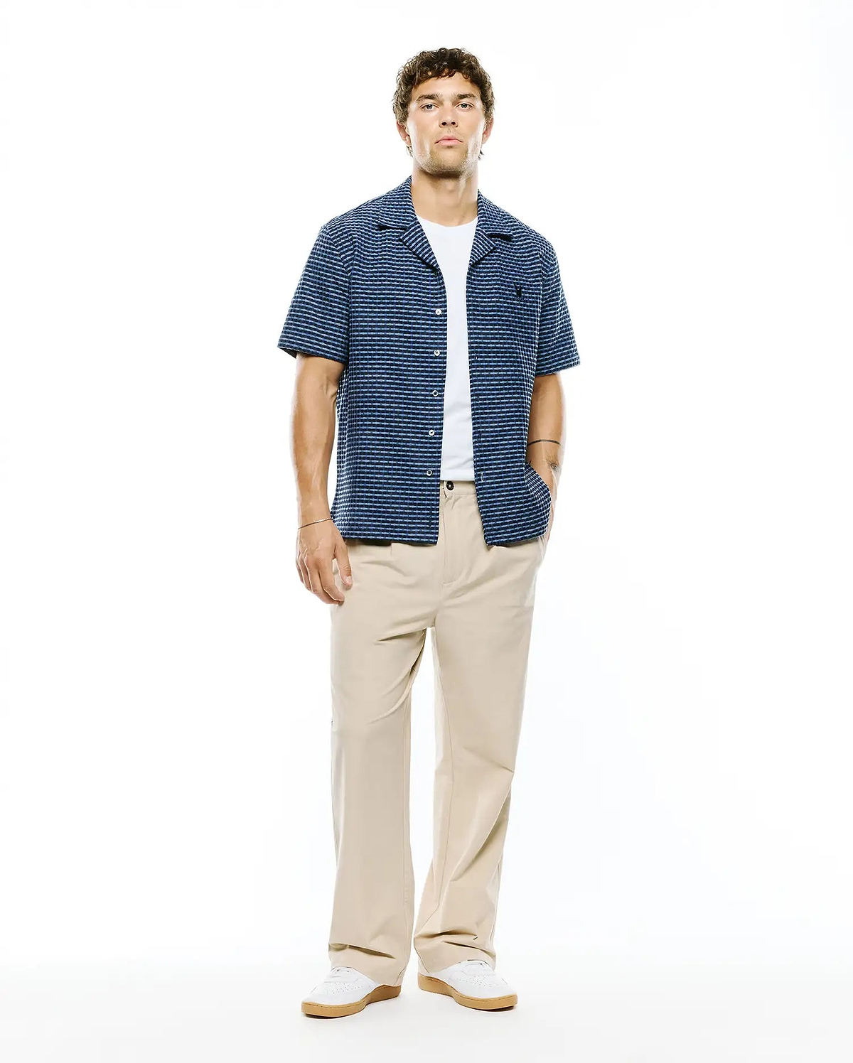 Mens Erik Raised Check Shirt: Relaxed fit navy blue short-sleeve camp collar shirt with light blue textured horizontal stripes, featuring a small embroidered Psycho Bunny skull logo on the left chest.
