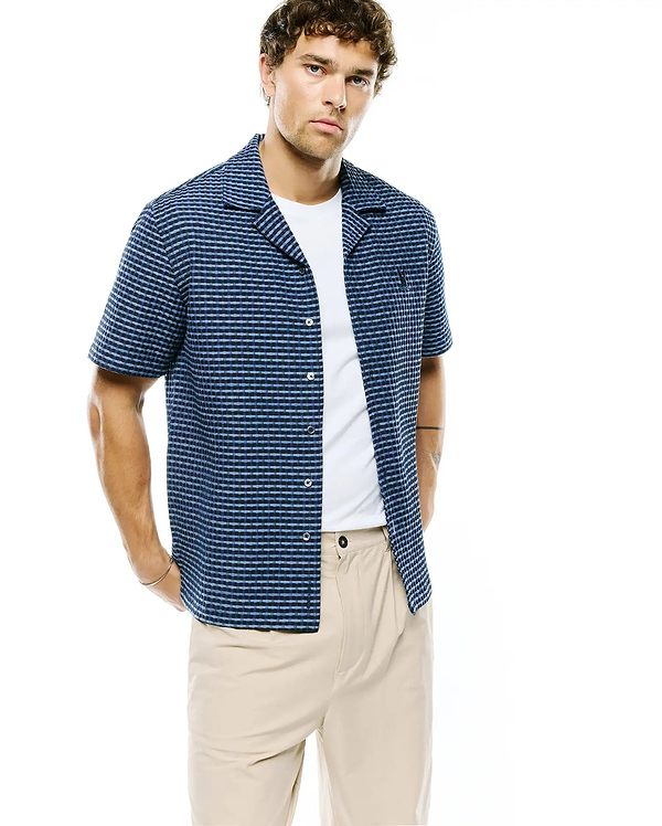 Mens Erik Raised Check Shirt: Relaxed fit navy and light blue textured short-sleeve shirt with a camp collar, featuring a subtle raised check pattern and a small embroidered Psycho Bunny skull logo on the left chest.