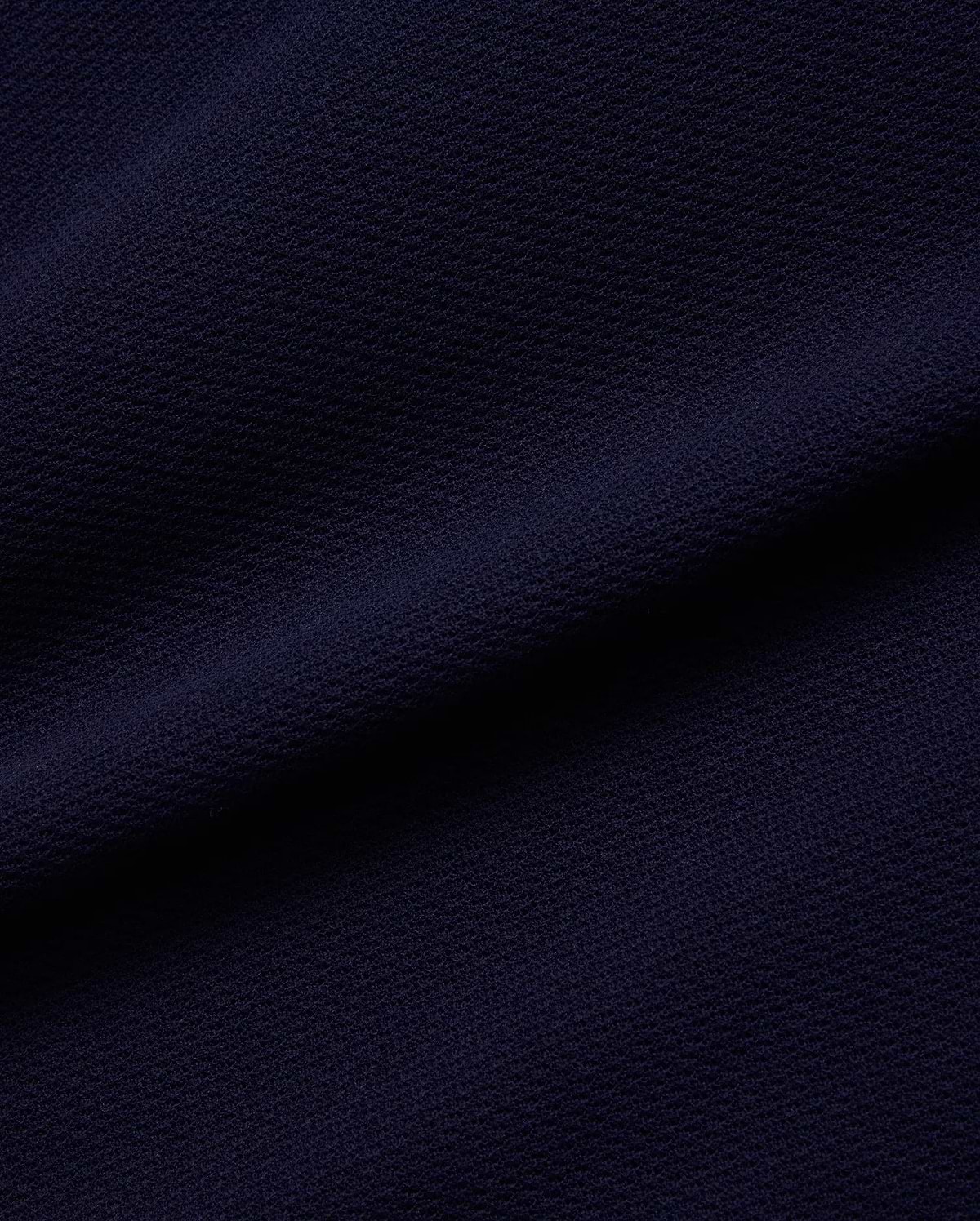 Psycho Bunny Mens Peter Knit Vest fabric in deep navy blue, featuring a premium, subtly textured knit surface, reflecting the brand's refined streetwear aesthetic.