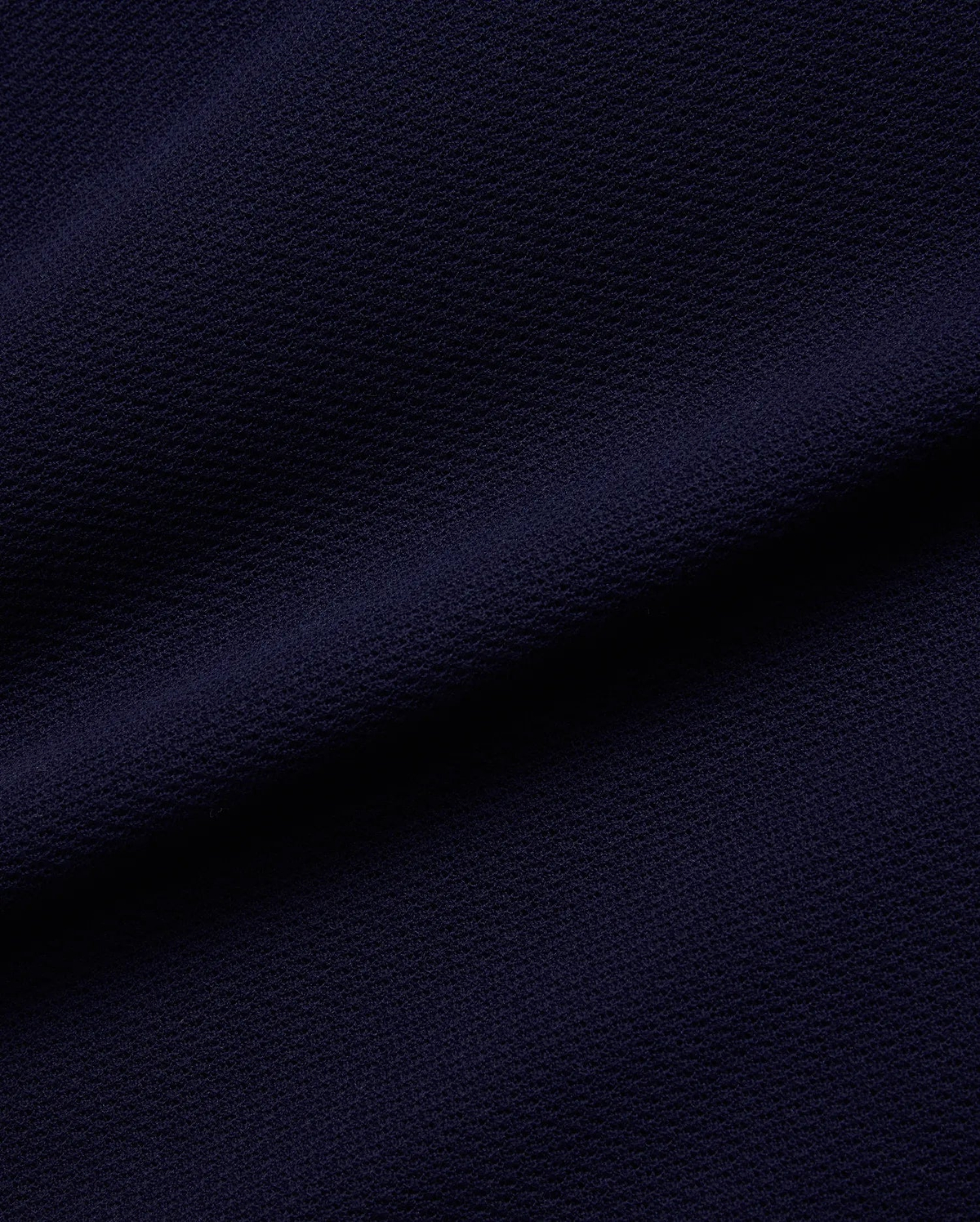 Psycho Bunny Mens Peter Knit Vest fabric in deep navy blue, featuring a premium, subtly textured knit surface, reflecting the brand's refined streetwear aesthetic.